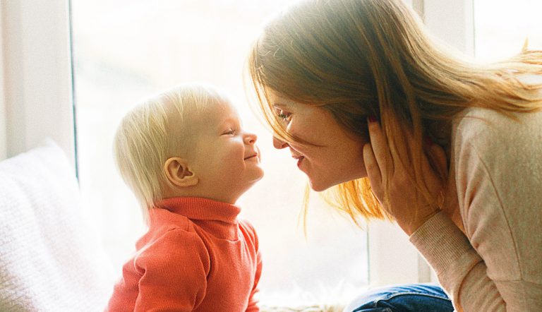 Moeder kijkt bij kindje naar mond of het krentenbaard of koortslip heeft
