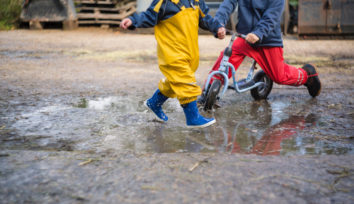 Kinderen die buiten spelen met laarzen in de plassen