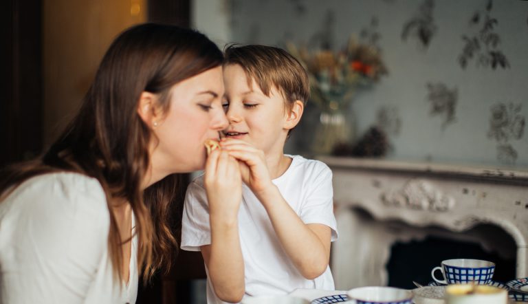 Jongetje die zijn moeder iets laat proeven aan tafel