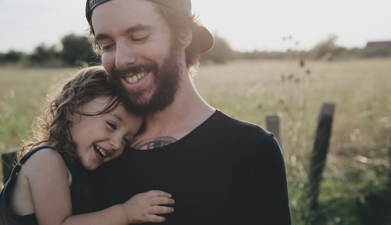 Meisje dat aan het knuffelen is met haar vader