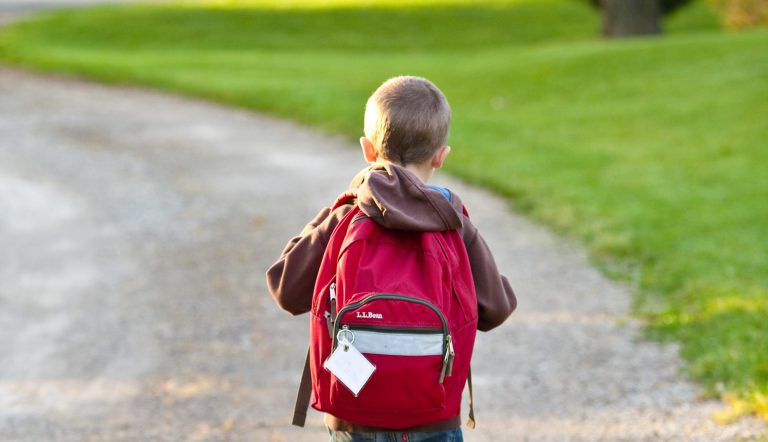 Jongetje dat naar de basisschool loopt