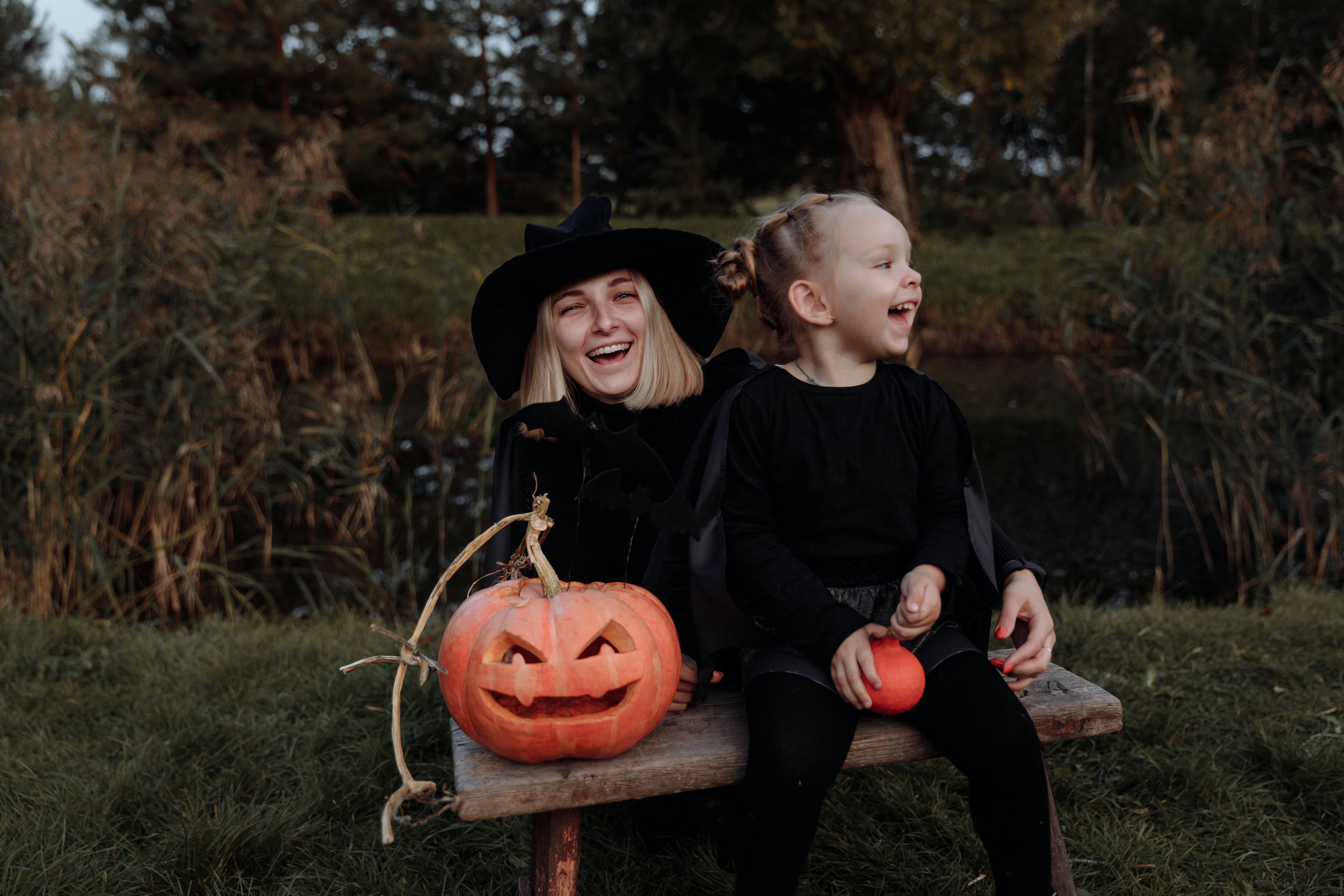 Moeder en dochter verkleed als heksen met pompoenen voor halloween die griezelfilms gaan kijken halloween hapjes