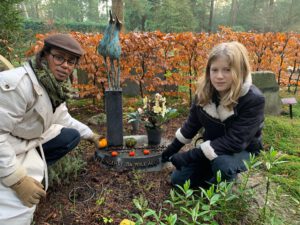 dood / vrouw en kind knielen naast graf