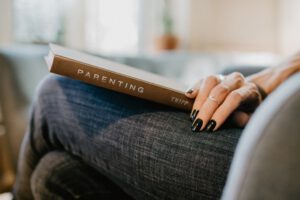 vrouw met boek over opvoeden op schoot