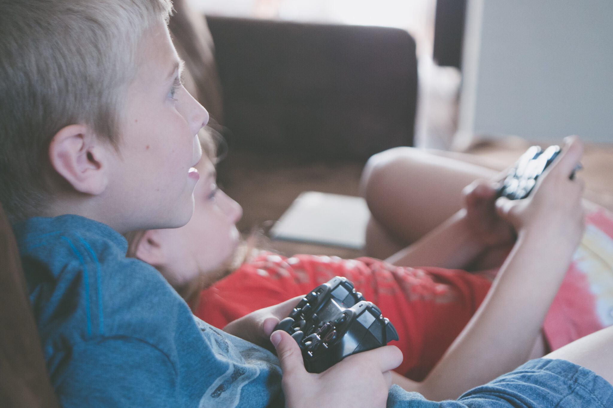 Twee kinderen met een game controller aan het gamen. Onderzoek naar mediagebruik en ADHD