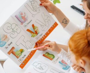 kind met vrouw letters aan het leren